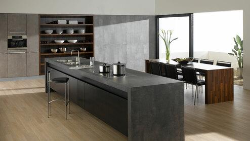 Küchen- und Esszimmerimpression mit einer Kombination aus Holz- und Stein-/ Betonoptik und Einbauschränken