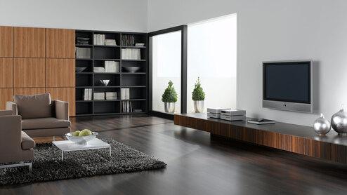 Wohnraumimpression mit verschieden dunklen Holzoberflächen für Einbauschrank, Sideboard und Bodenbelag